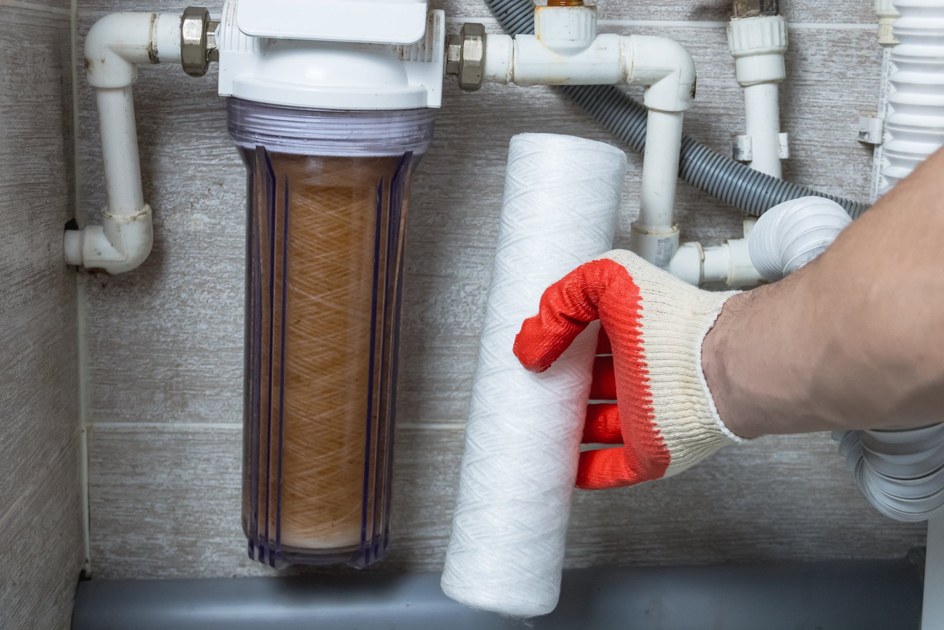Professional plumber installing water filter
